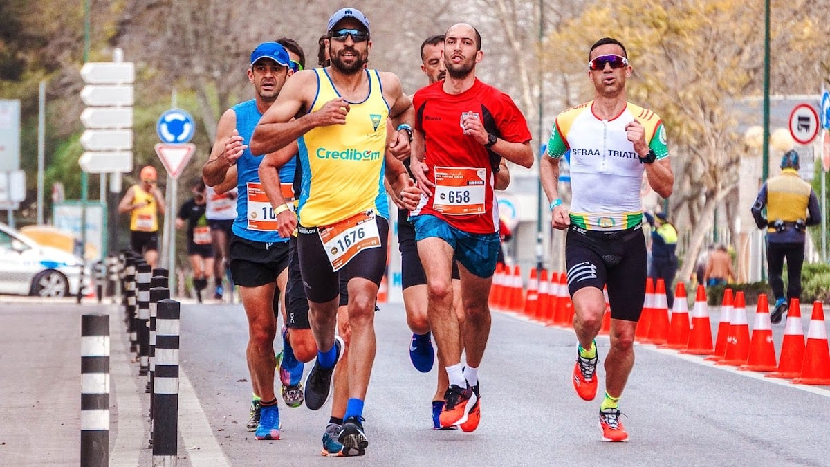 Men running in a marathon, thinking about joining a remote coding bootcamp.