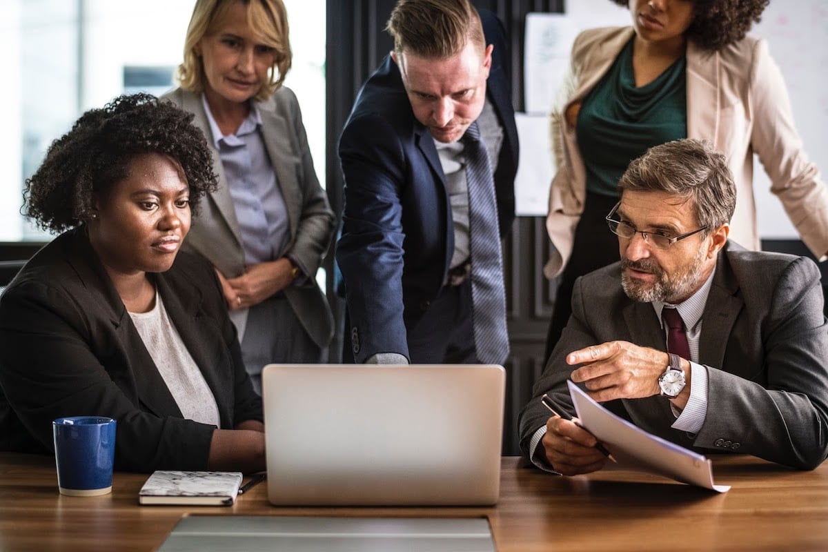 Image of a team of professionals working around a computer.