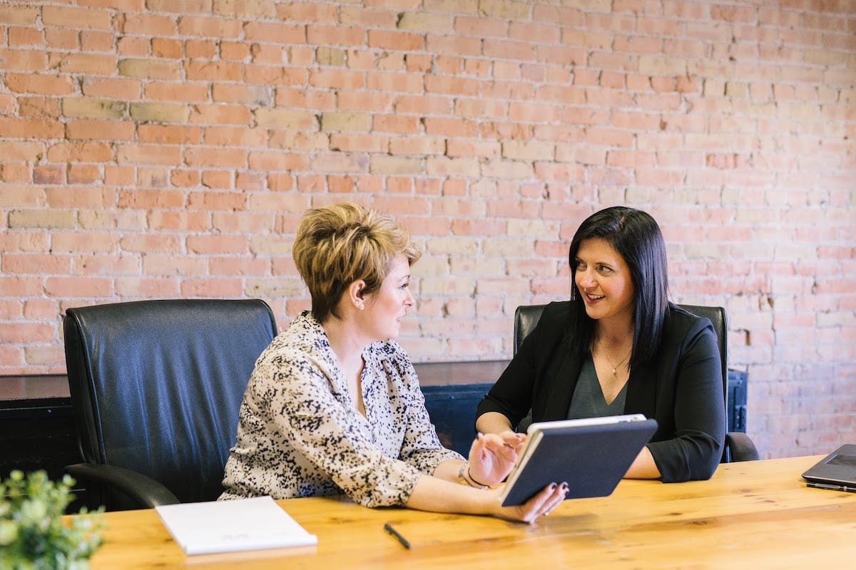 A UCLA coding bootcamp student and her instructor interacting in a meeting room
