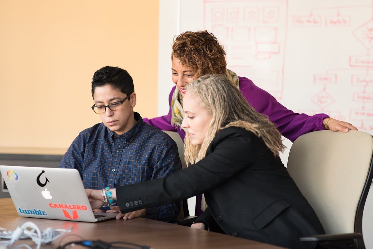 Image of people collaborating around a computer.