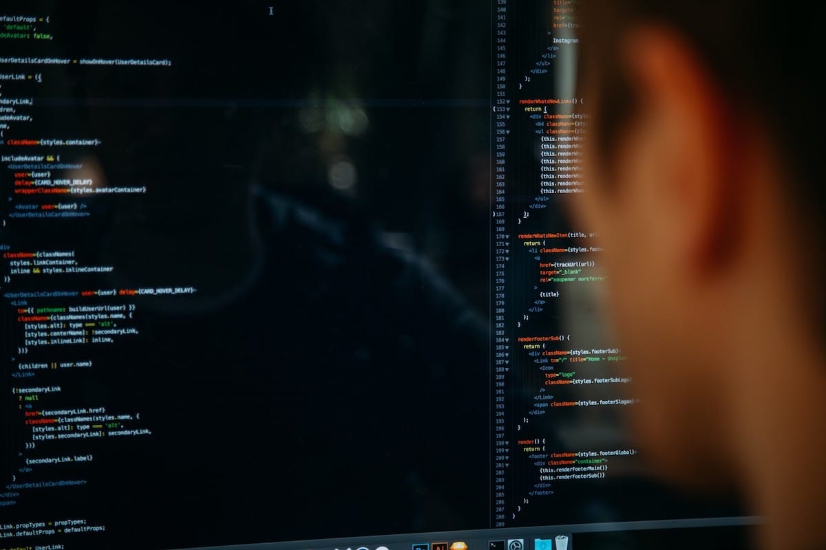 A person looking at multiple lines of code on a computer screen.