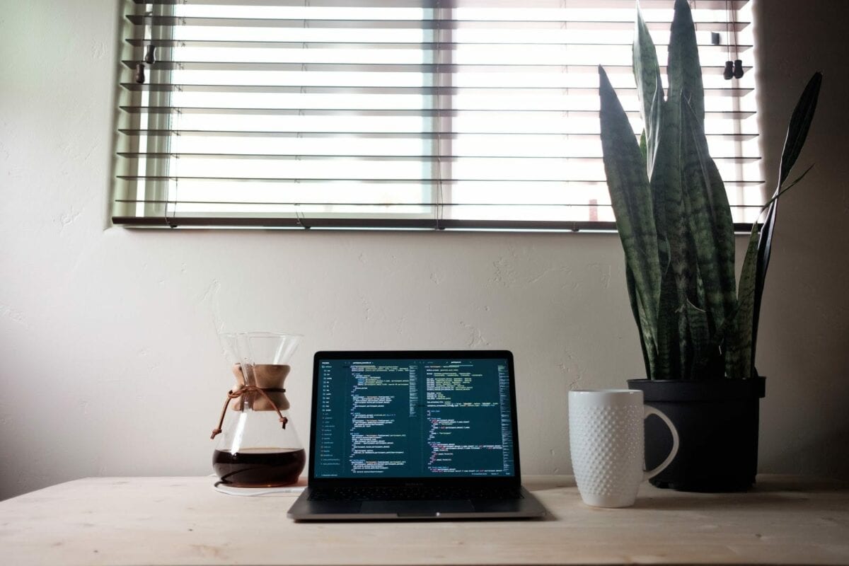 Image of laptop with code and coffee cup.