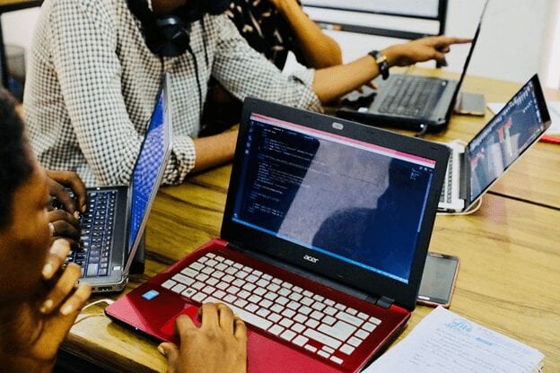 image of group of people working on laptops.”