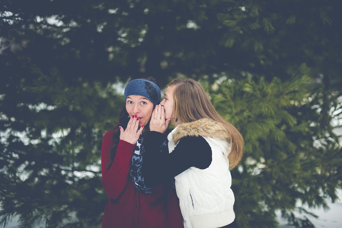 “Picture of two women sharing a secret.”
