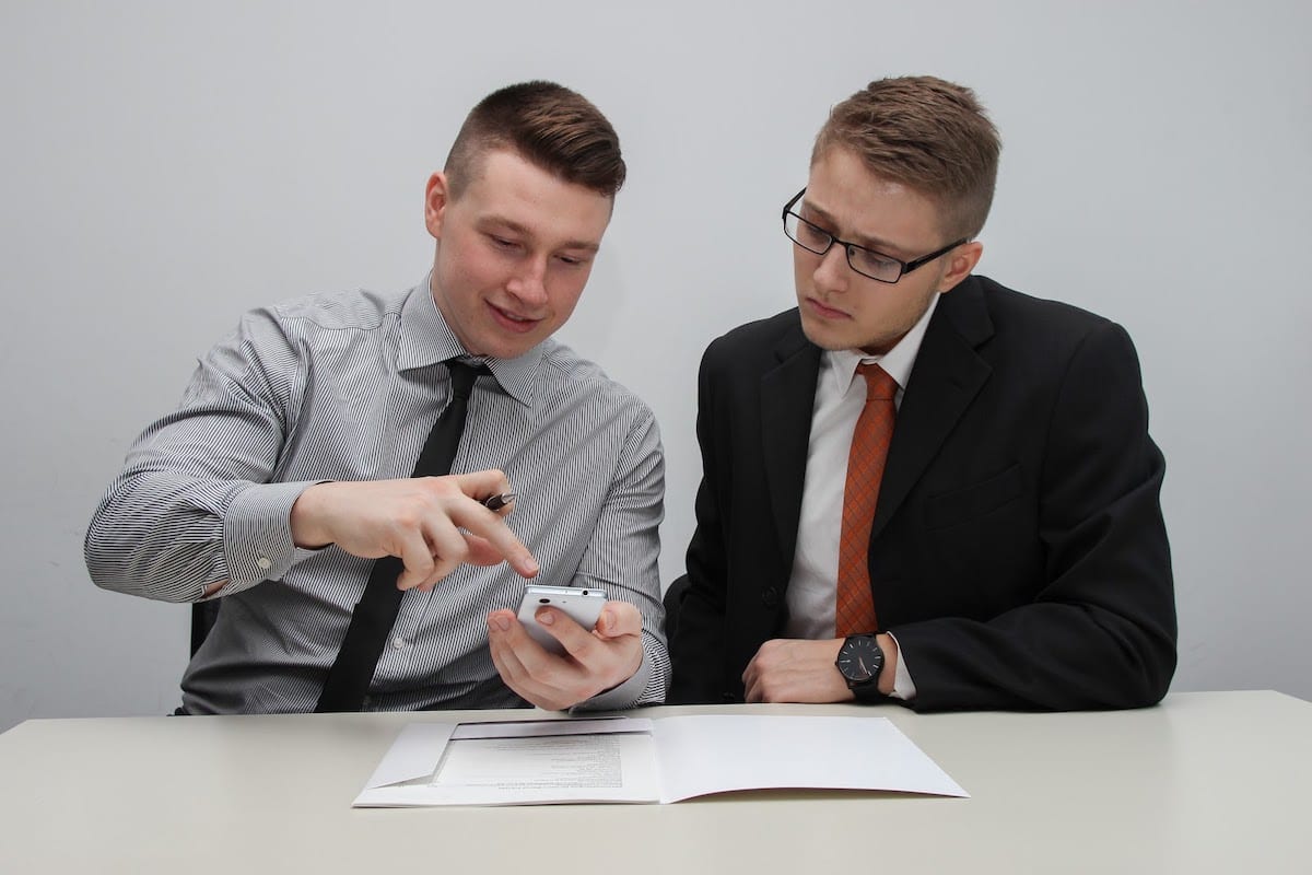 Two men watching smartphone