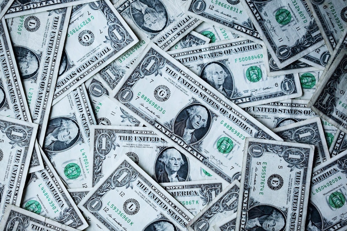 A pile of spread-out one-dollar bills. 