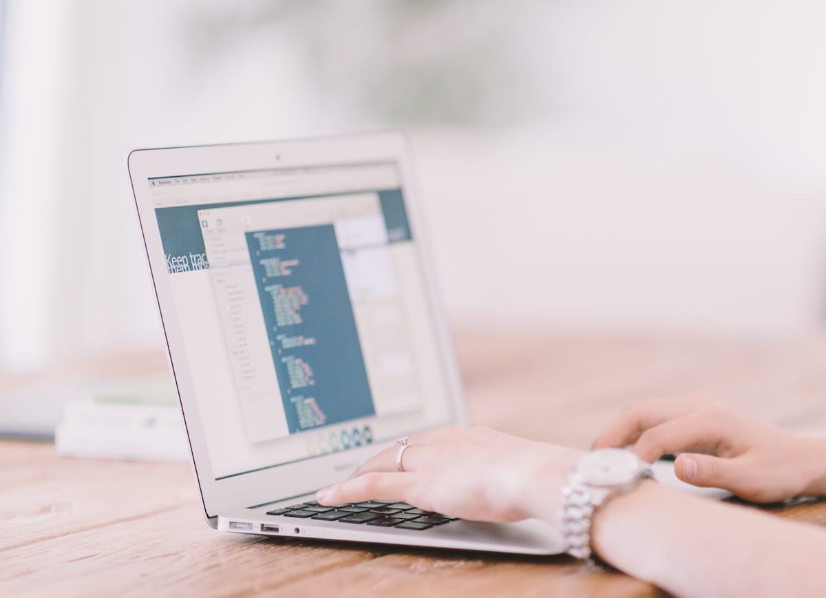 Image of a person coding on a laptop.