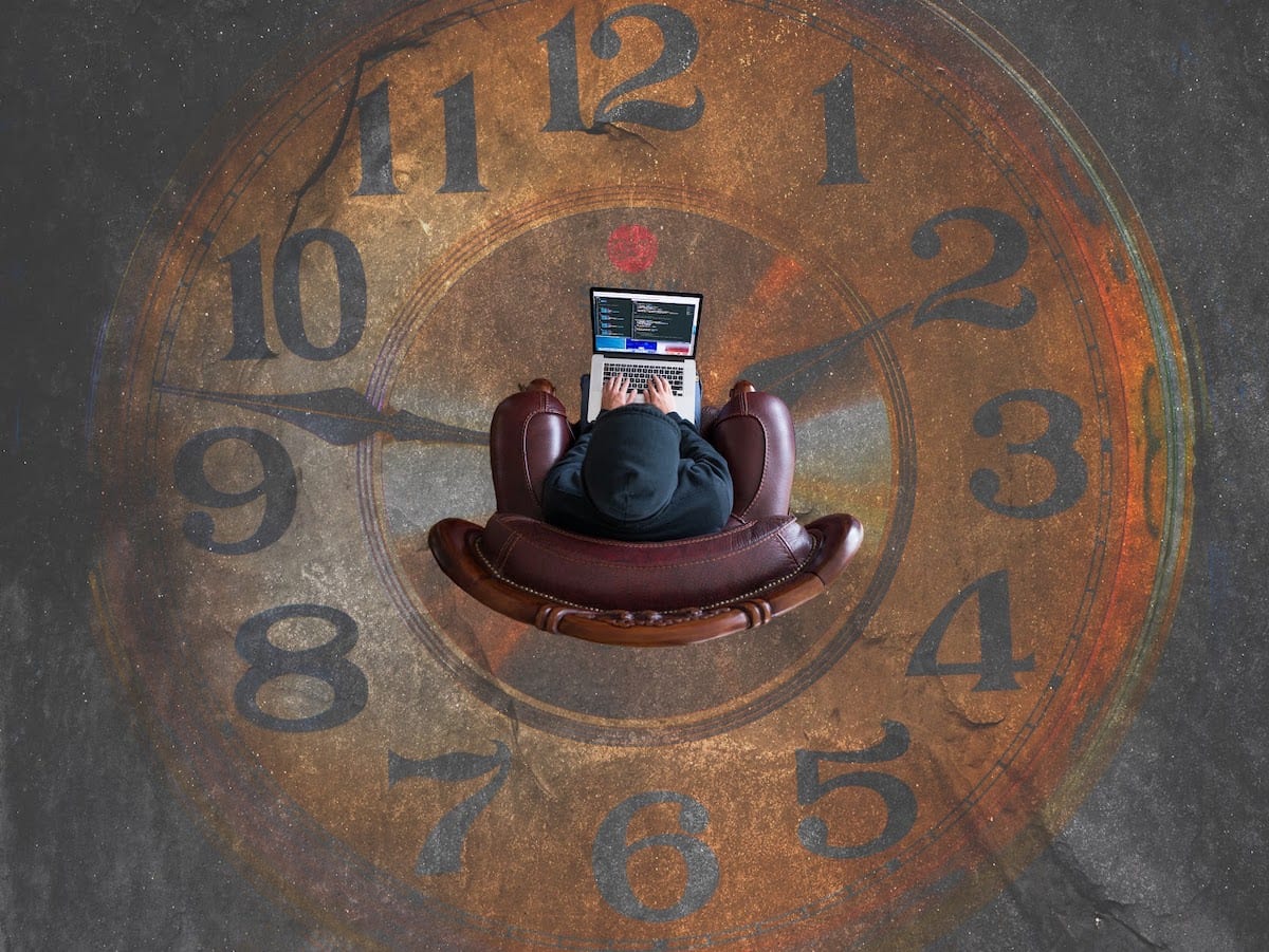 Image of a coder sitting on a clock painting. 