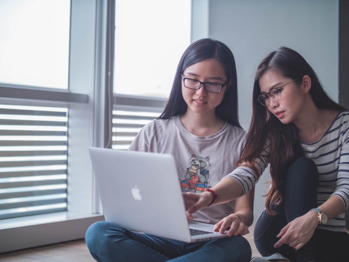 Two women collaborating over the laptop