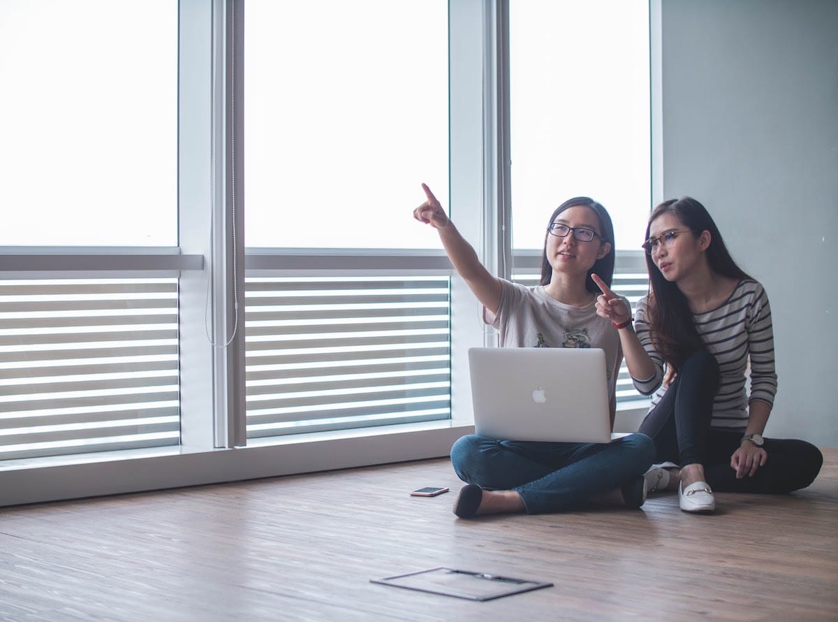 Image of women collaborating around a computer.