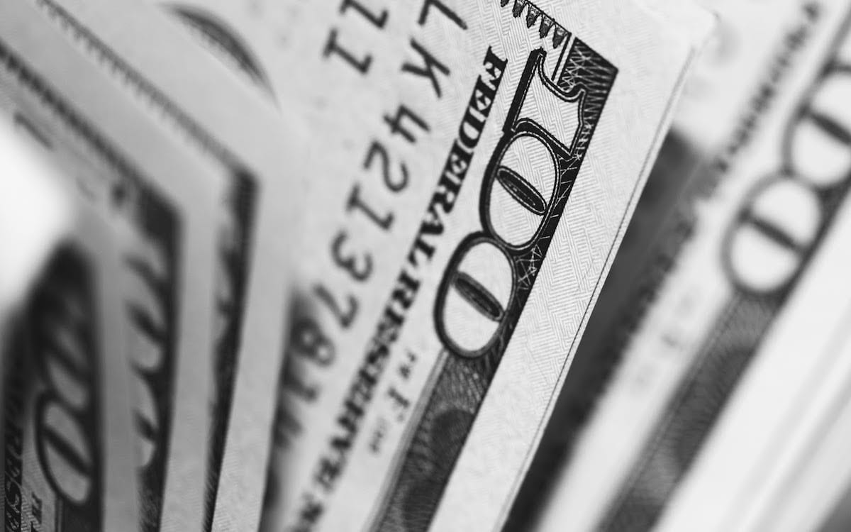 A black and white image of one-hundred-dollar bills. 