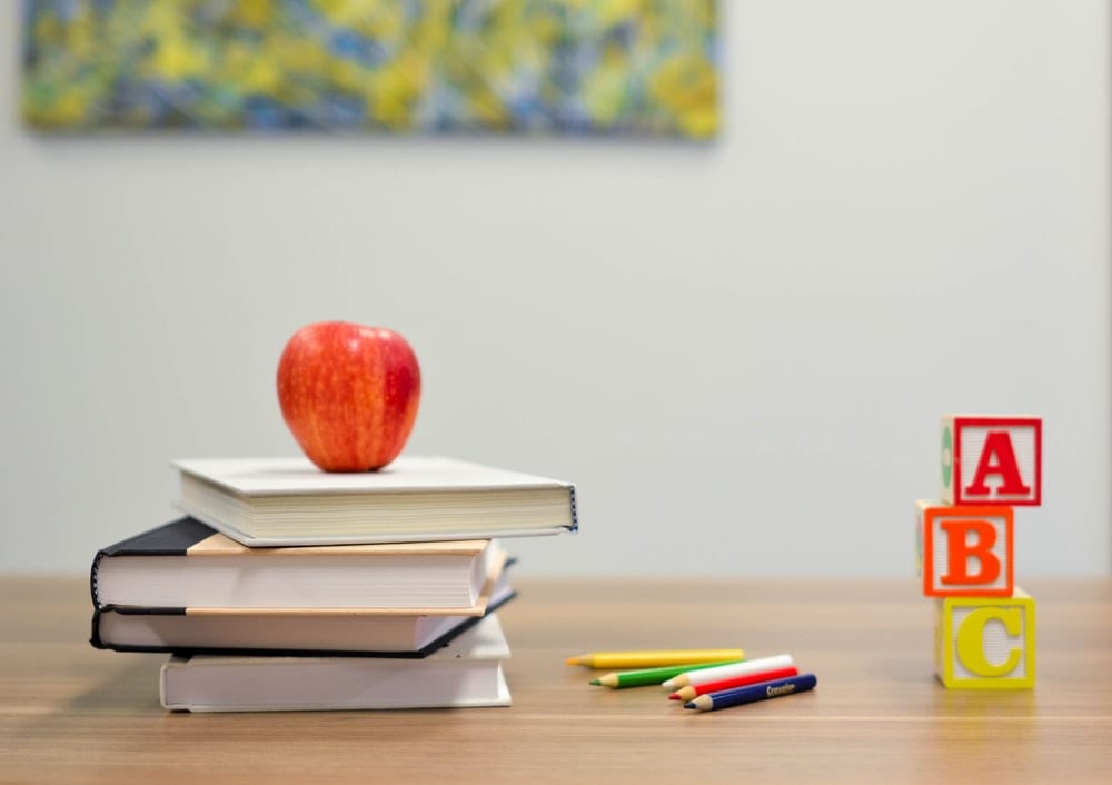 An apple on top of some books.