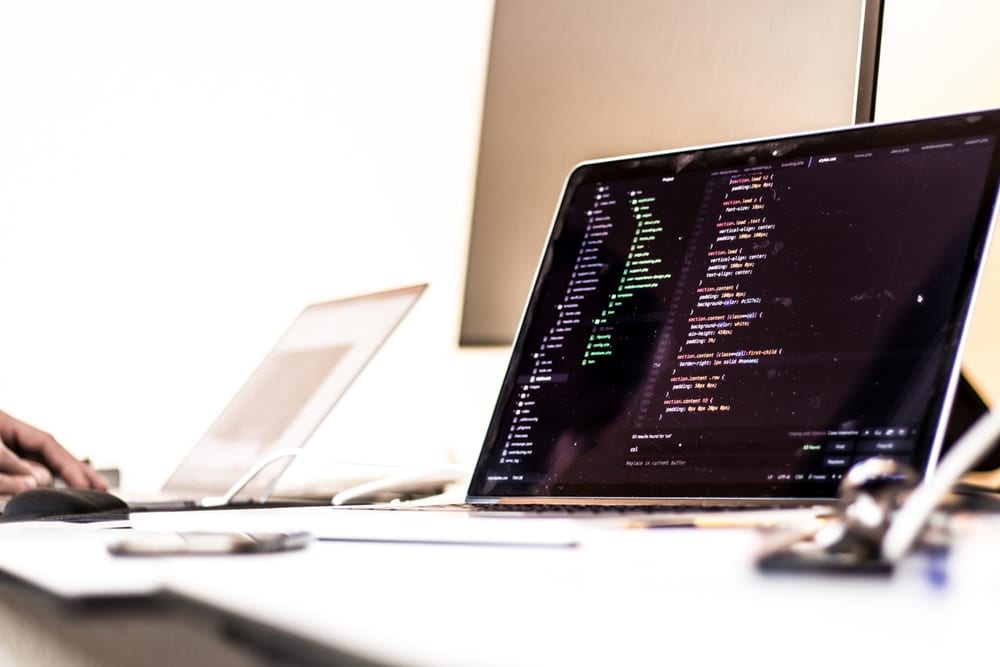  black laptop computer turned-on displaying source code on table