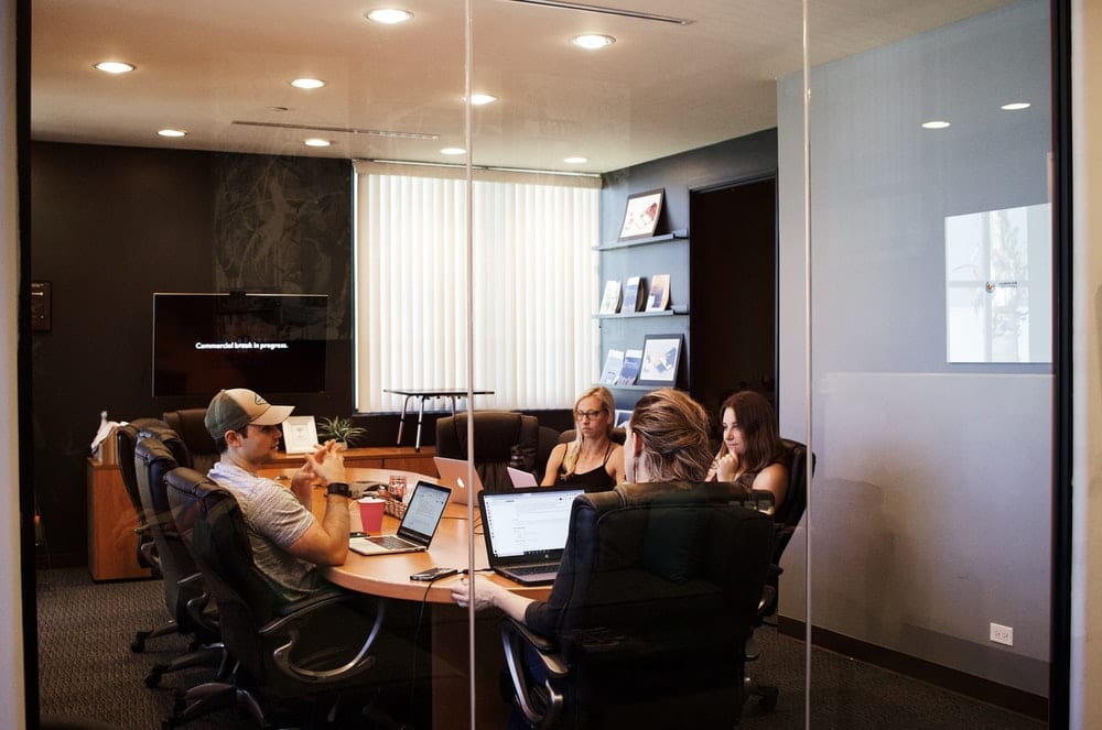 people sitting near table with laptop computers