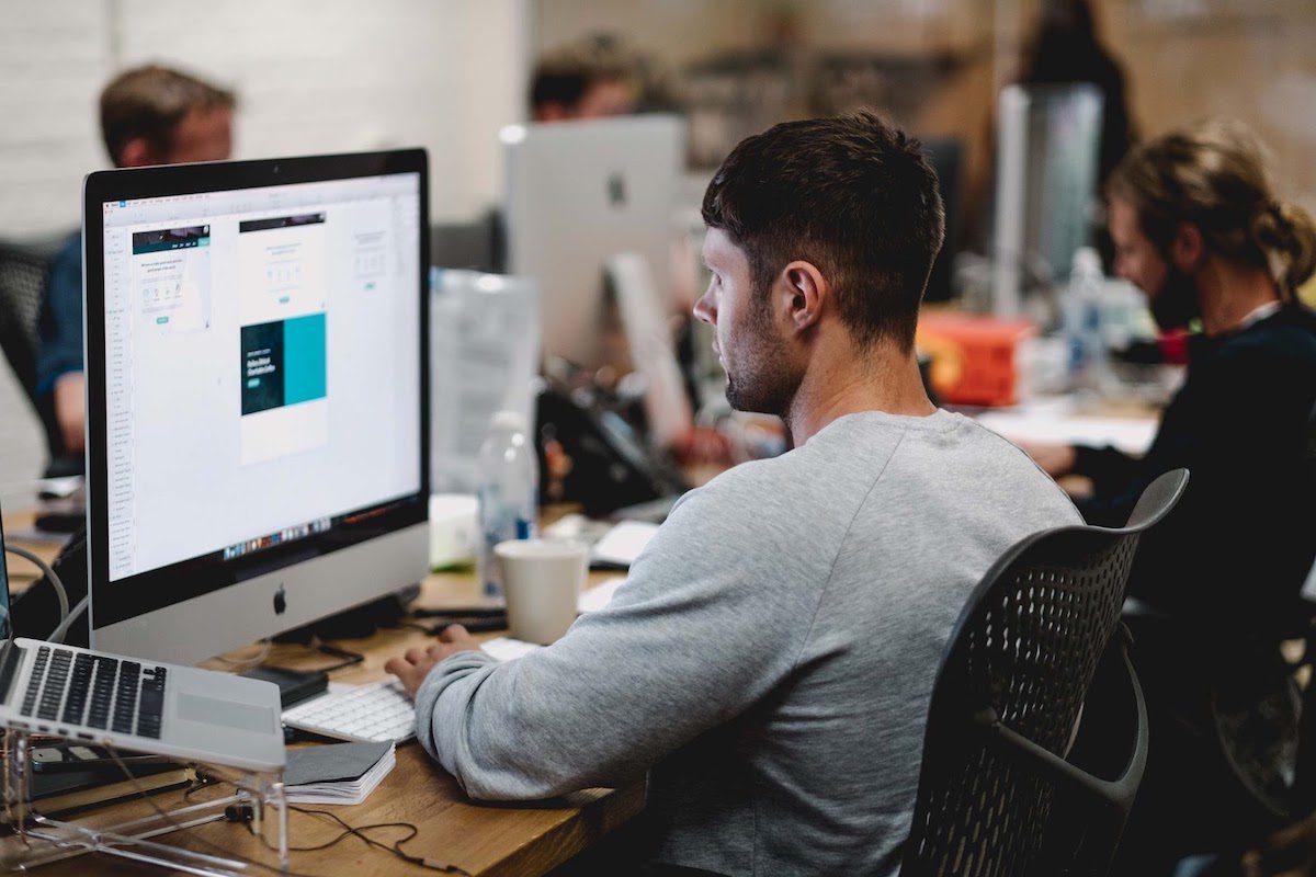 a tech worker looking at a computer screen in an office