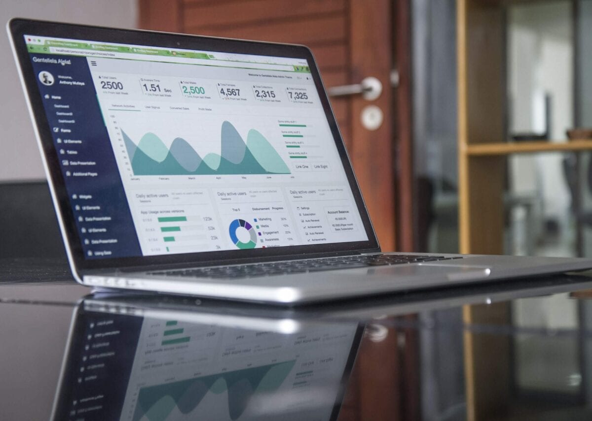 Open laptop on desk displaying graphs of data