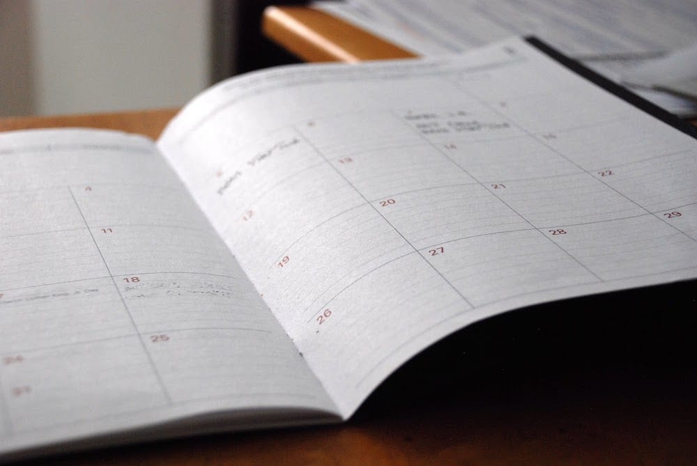 An open agenda notebook showing a one-month calendar.