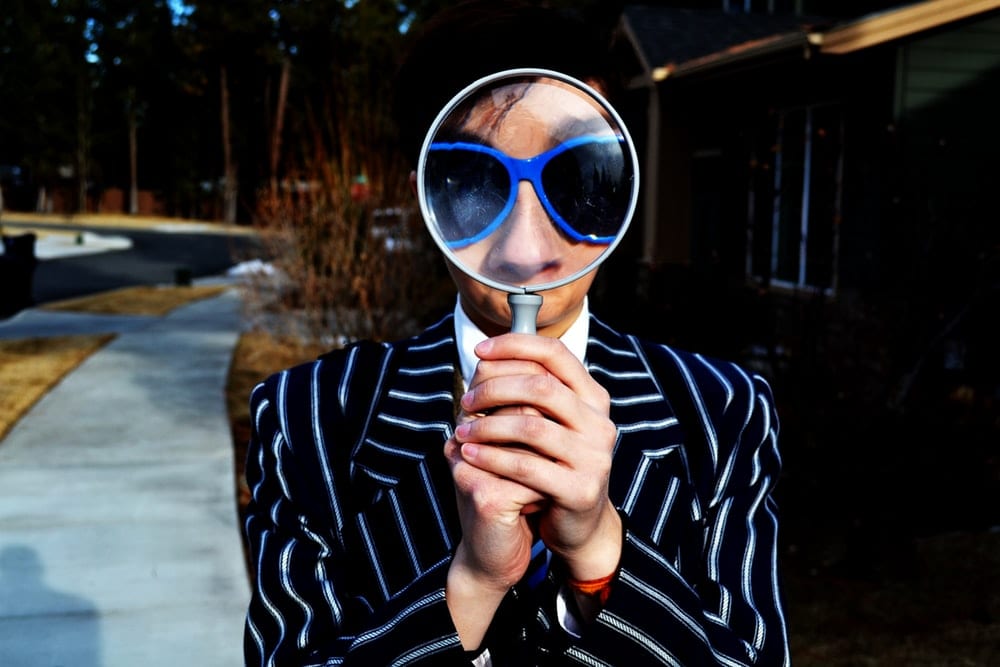 Man looking through a magnifying glass.