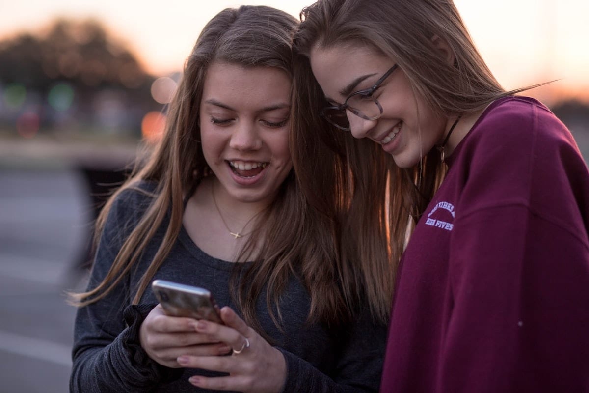 two girls looking at a phone