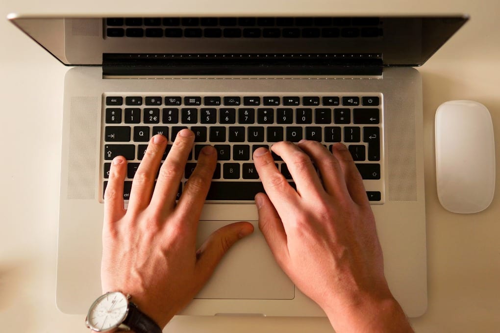 Overhead shot of hands typing on a computer