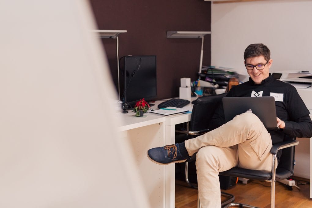 A person smiling while working on a computer