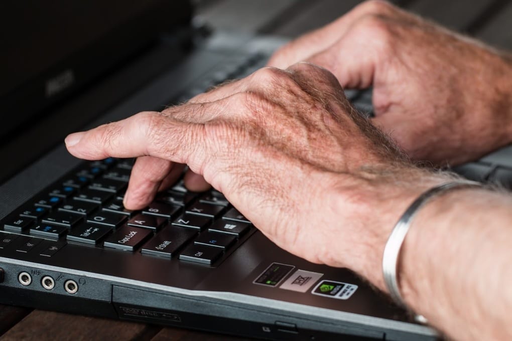 man typing at laptop