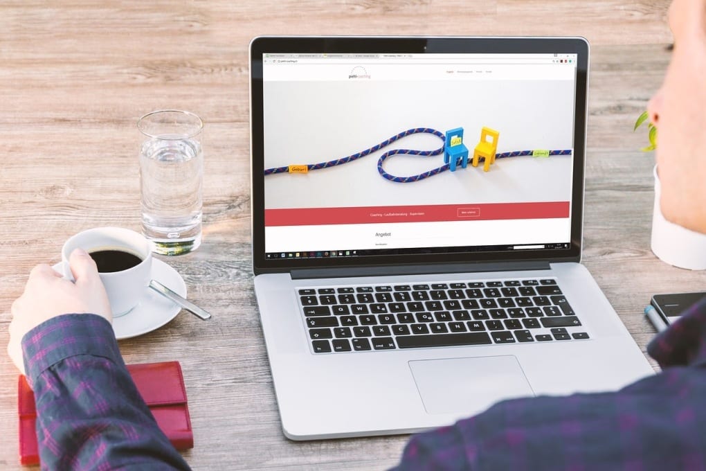 woman drinking coffee sitting at laptop