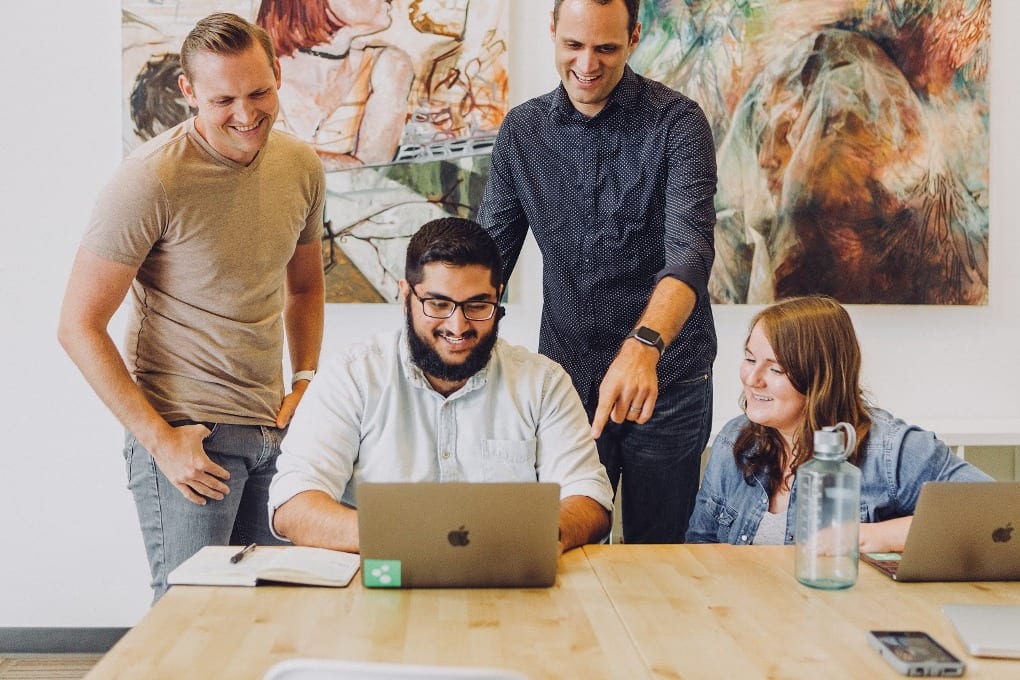 A group of people looking at one computer