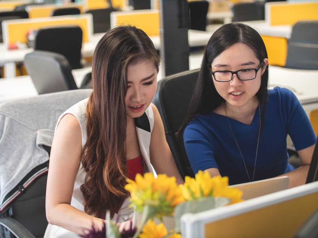 Two people looking at a computer together.