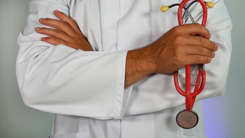 A person in lab coat holding a stethoscope