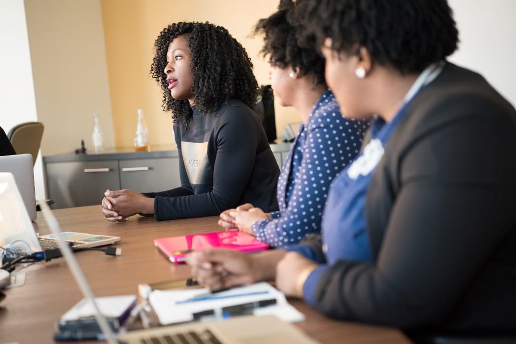 Several tech employees sitting at a conference table. 