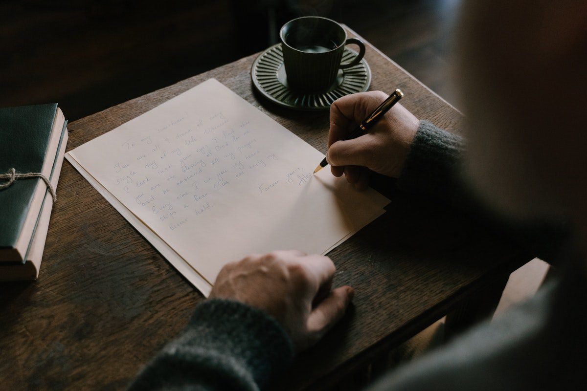 A person drafting a compelling letter on a paper How To Write A Letter Of Interest