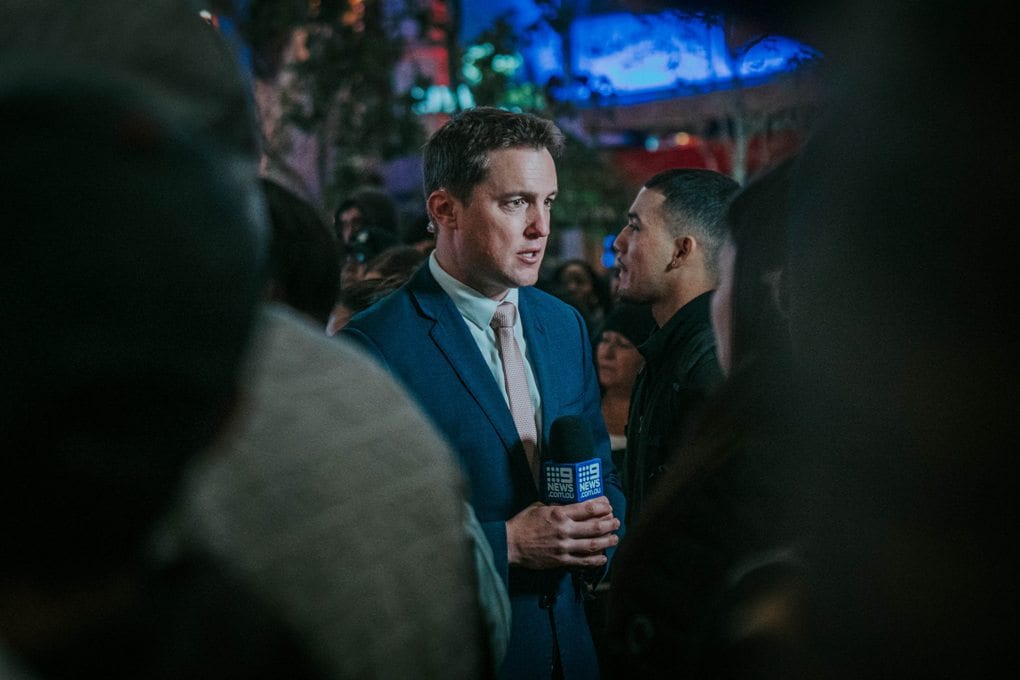 man reporter speaking in a crowd