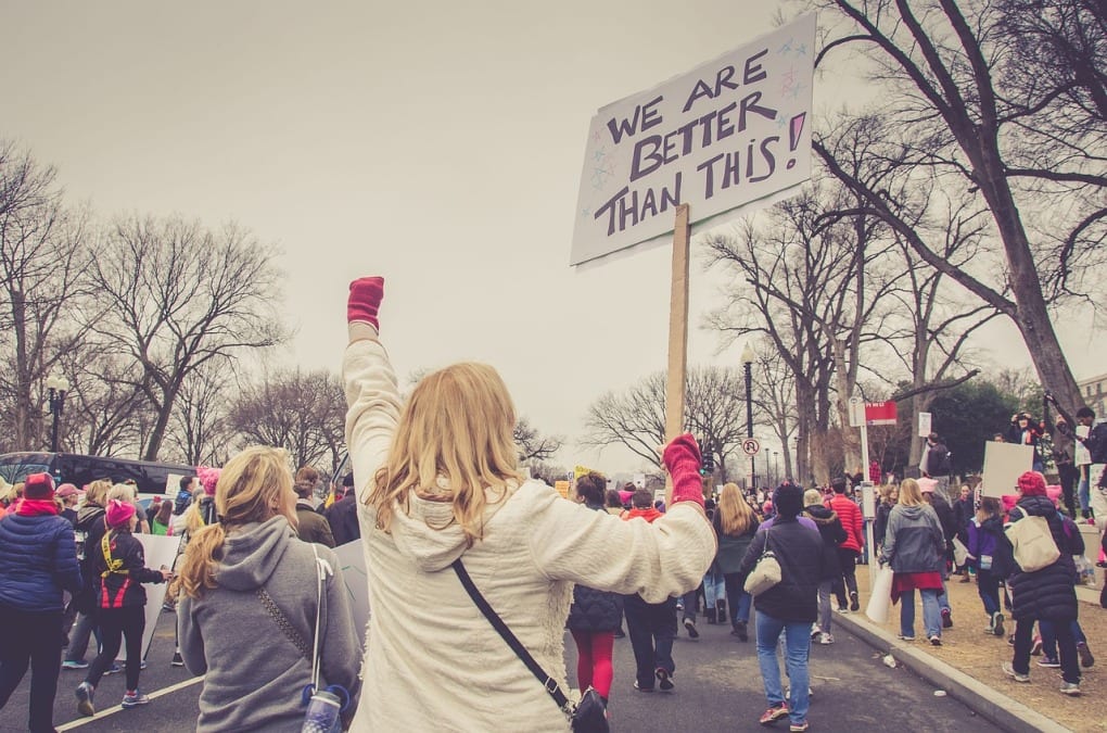 a woman at protest holding sign