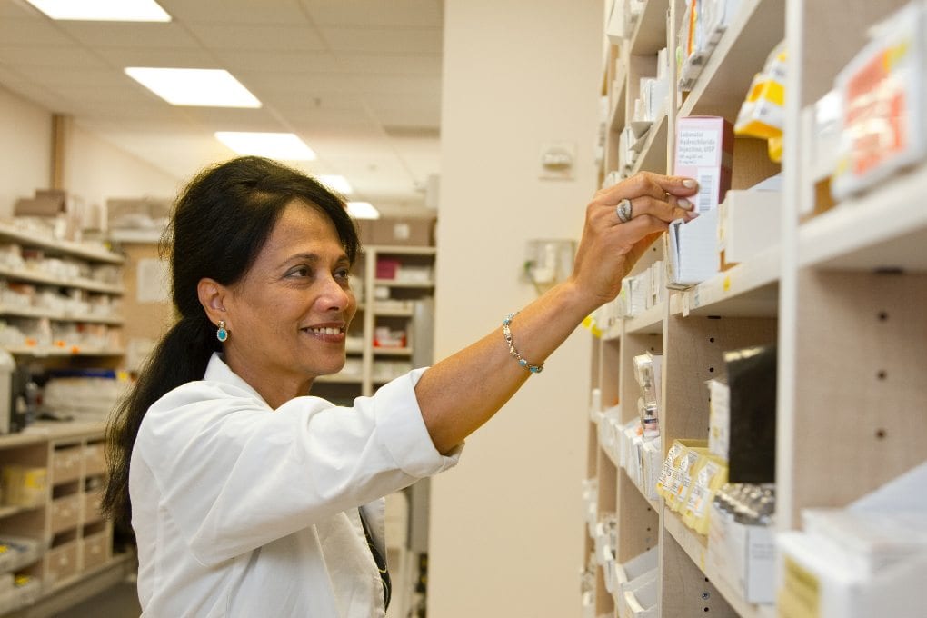 Female pharmacist tech organizing medications
