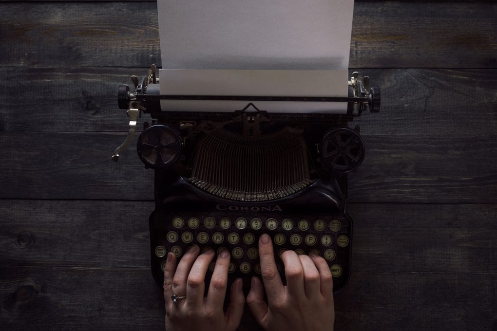 Hands type on an old typewriter
