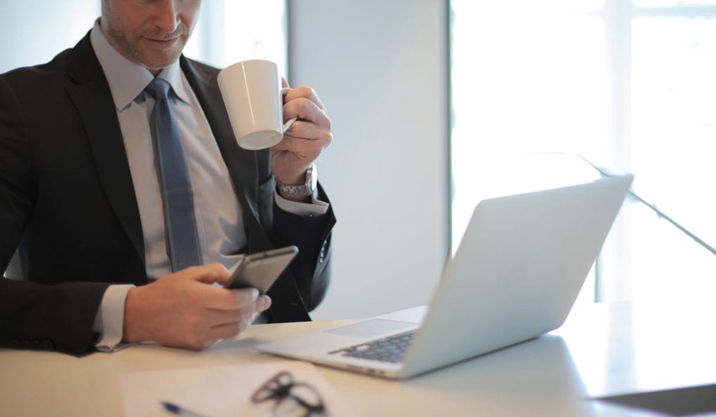 man in black suit drinking coffee
