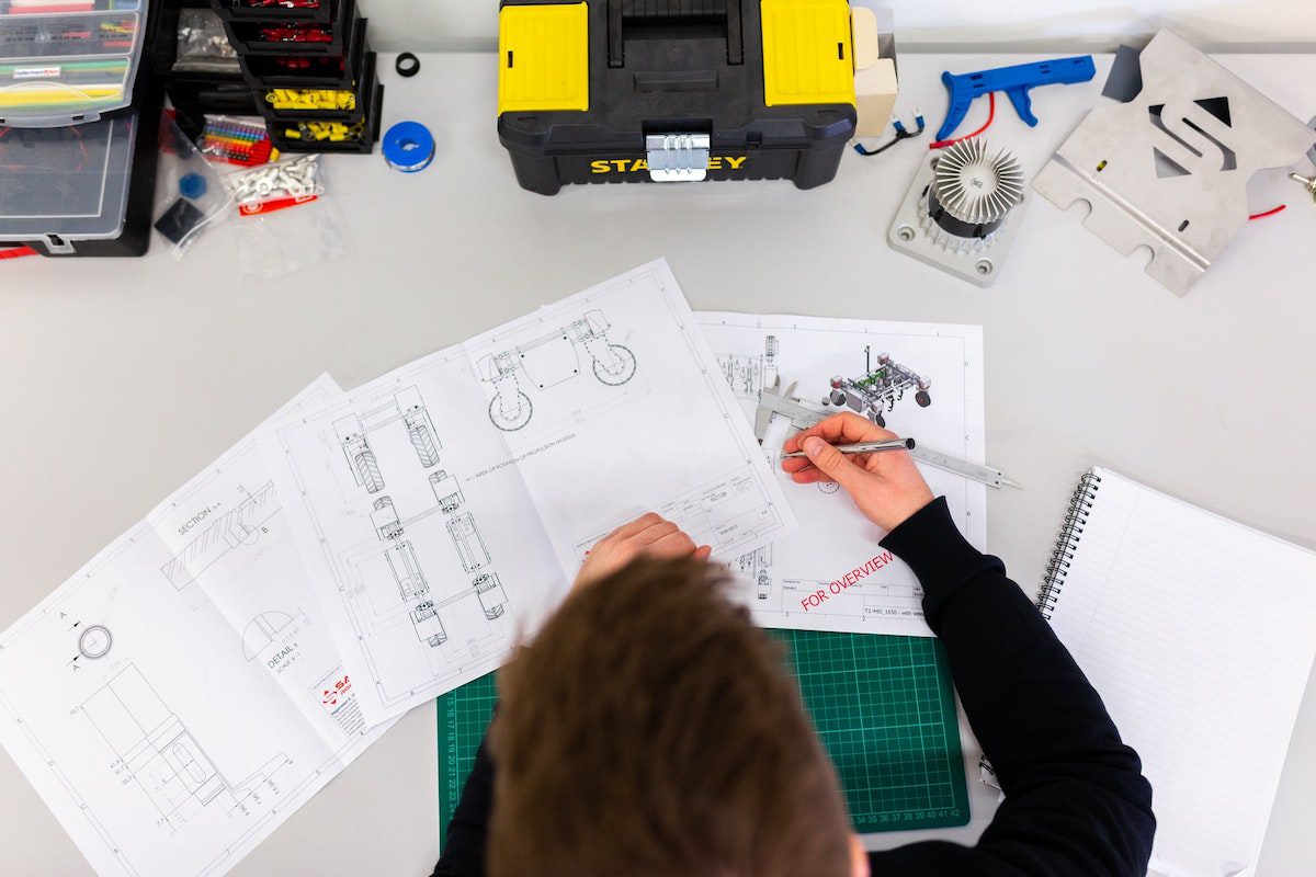 a bird’s-eye view of an engineer designing blueprints and sketches as part of his technical education Engineering Bachelor's Degrees
