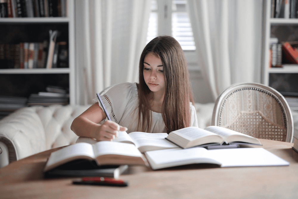 Girl sitting at a table and studying hard to pass her advanced classes