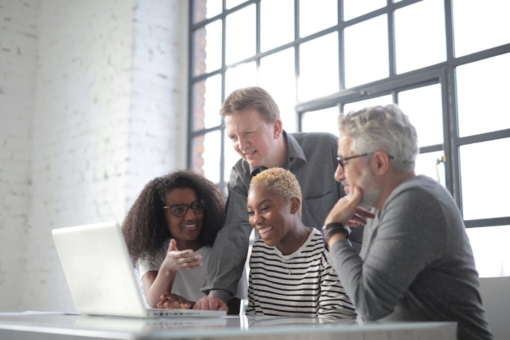 Coworkers discussing project on laptop