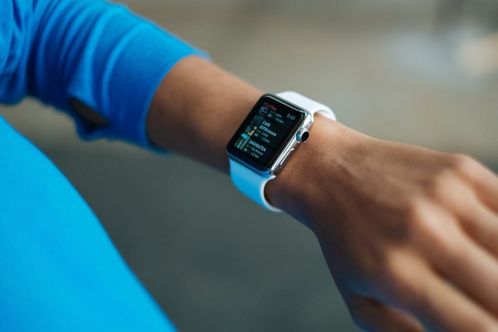 a person wearing a white silicone strap smartwatch