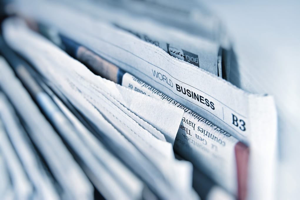 A stack of newspapers. The world business section is visible.