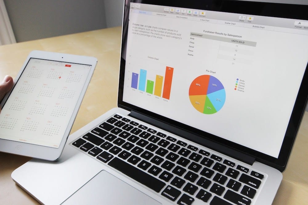 A laptop computer using a pie chart and a bar graph to illustrate interactive data visualization.