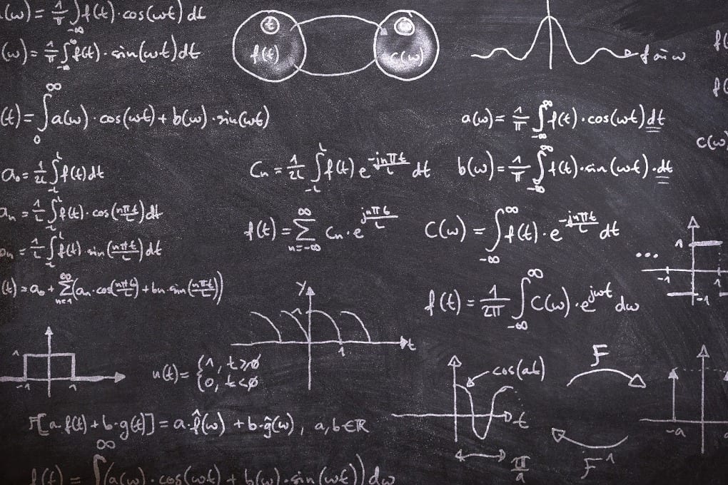 math equations, graphs, and figures written on a blackboard