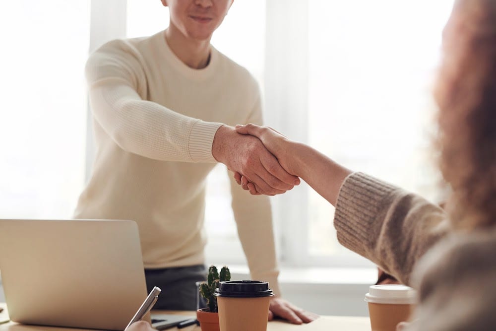 Two individuals shaking hands after making an agreement to learn Tableau.