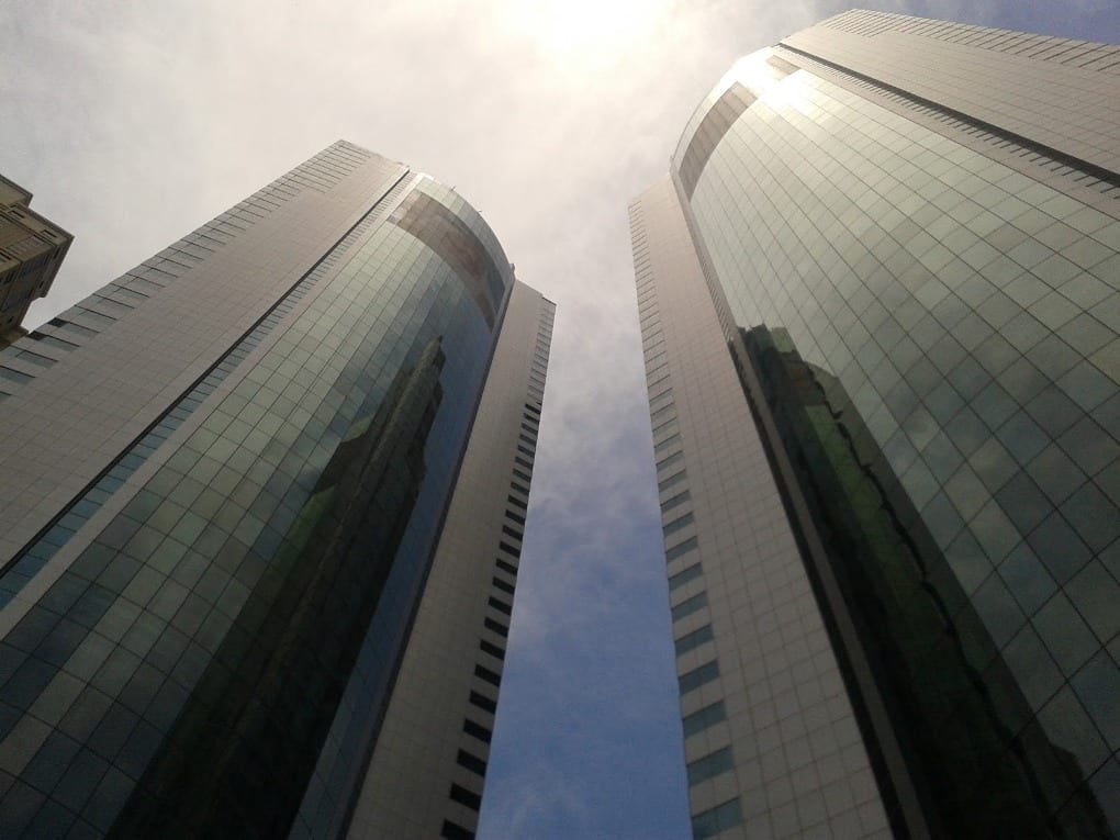 worm’s-eye view of two skyscrapers and the sun