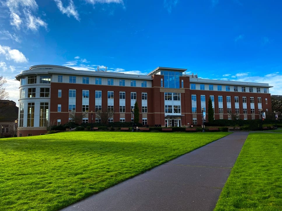 Modern brick and concrete academic building under a blue sky