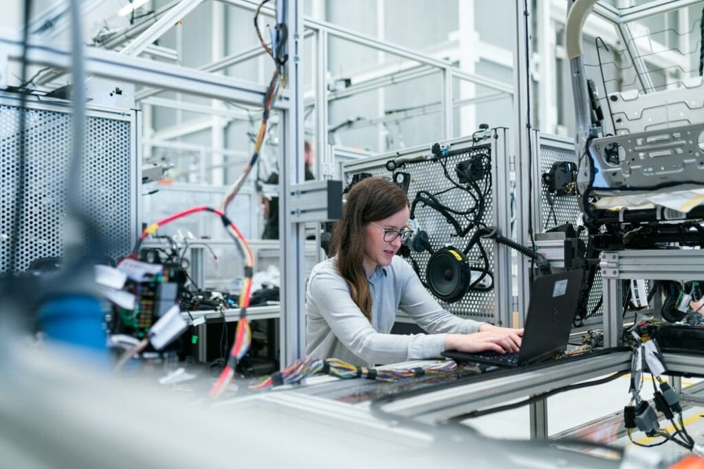 Female electronics engineer running vehicle tests on a laptop 