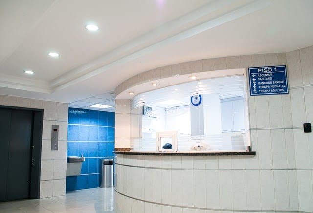 White tile walls and an empty reception desk. 
