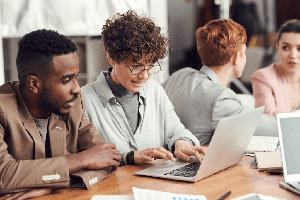 
Alt: Woman showing her coworker her laptop screen